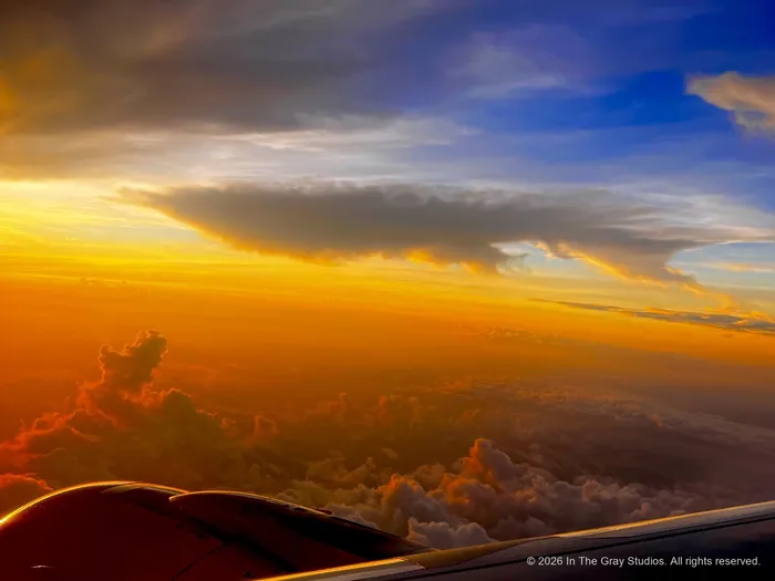 Sunset burning orange along the cloud layer, seen from above